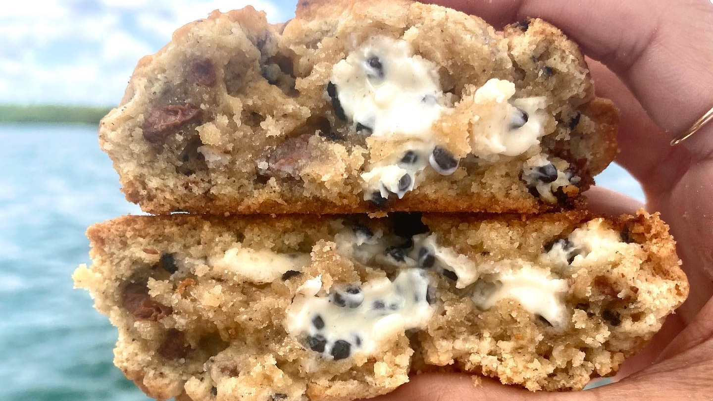 Cookies held in front of a lake